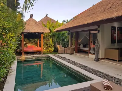 a villa with a swimming pool and a resort at Villa Kakariki in Kerobokan