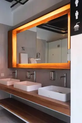 a bathroom with two sinks and a mirror at M Boutique Hostel Legian in Legian