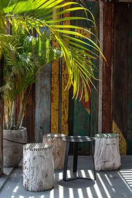 a table and two potted plants in front of a wall at M Boutique Hostel Legian in Legian