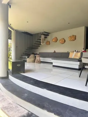 a living room with a couch and a staircase at SuB Villas Bali in Canggu