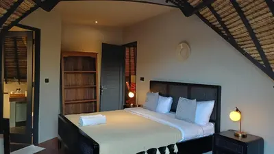 a bedroom with a large bed with white sheets at SuB Villas Bali in Canggu