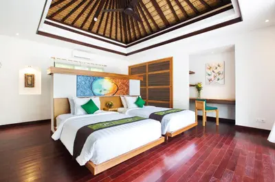 a bedroom with two beds and a desk at Sunset Paradise Jimbaran 3003 in Jimbaran