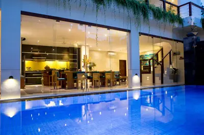 a swimming pool in front of a house with a dining room at Sunset Paradise Jimbaran 3003 in Jimbaran