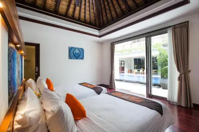 two beds in a room with a large window at Sunset Paradise Jimbaran 3003 in Jimbaran