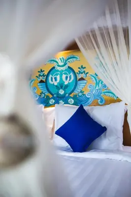 a bedroom with a bed with a blue head board at Sunset Paradise Jimbaran 3003 in Jimbaran