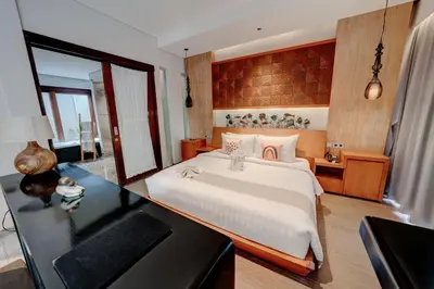 a bedroom with a large bed and a desk at Mokko Suite Villas Umalas Bali in Seminyak
