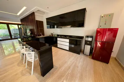 a kitchen with a black counter and a red refrigerator at Mokko Suite Villas Umalas Bali in Seminyak