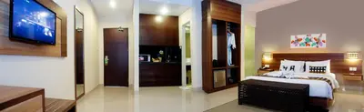 a bedroom with a large bed and a television at Grand Barong Resort in Kuta