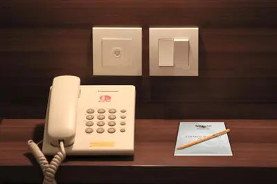 a white phone sitting on top of a wooden table at Grand Barong Resort in Kuta