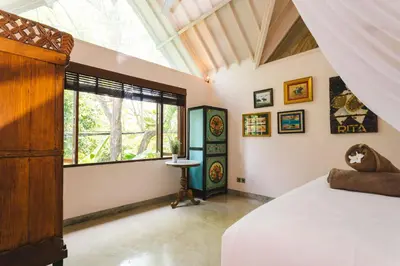 a bedroom with a bed and a large window at Villa Vickary Seminyak in Seminyak