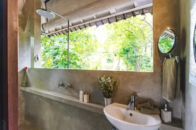 a bathroom with a sink and a large window at Villa Vickary Seminyak in Seminyak