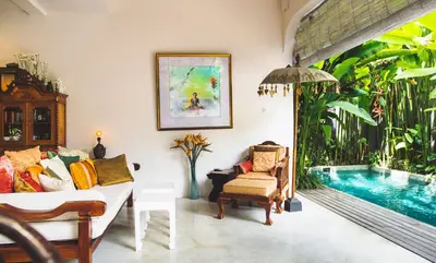 a living room with a couch and a swimming pool at Villa Vickary Seminyak in Seminyak