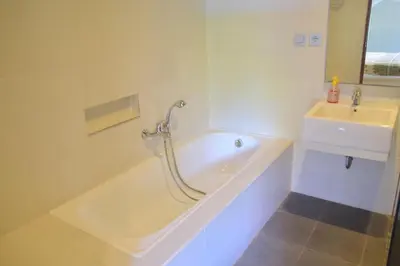 a white bathroom with a tub and a sink at Villa Putu Mira By Maha Bali in Kuta