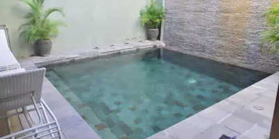 a swimming pool in the middle of a yard at Villa Putu Mira By Maha Bali in Kuta