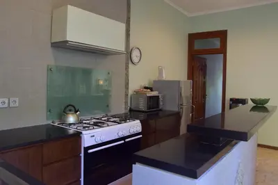 a kitchen with a stove and a refrigerator at Villa Putu Mira By Maha Bali in Kuta