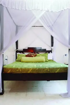 a bedroom with a bed with a canopy at Villa Putu Mira By Maha Bali in Kuta