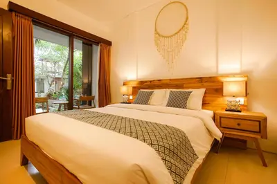 a bedroom with a large bed with a mirror on the wall at The Kubu Hotel in Kuta