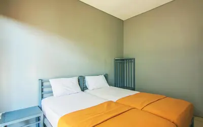 a bedroom with a bed with an orange blanket at The Kubu Hotel in Kuta