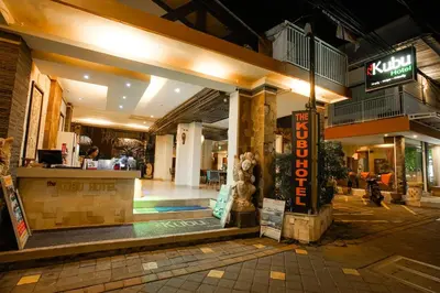 a restaurant with a counter in a building at night at The Kubu Hotel in Kuta