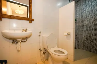 a bathroom with a toilet and a sink at The Kubu Hotel in Kuta