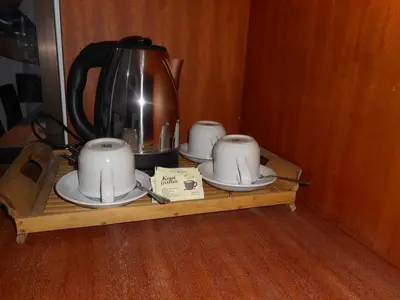 a shelf with three cups and a tea kettle on it at Grand Sinar Indah in Legian