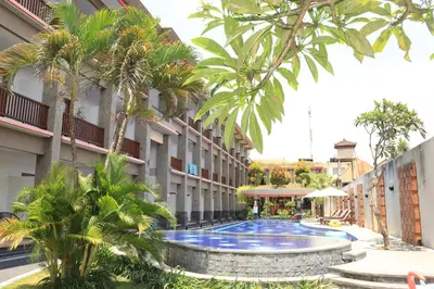 a swimming pool in the middle of a building at Grand Sinar Indah in Legian