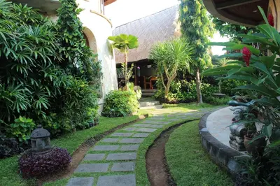 a garden with a stone path in front of a house at Dewani Villa Resort in Canggu
