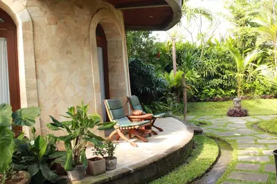 a patio with two chairs and a table at Dewani Villa Resort in Canggu