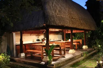 a pavilion with a table and chairs and a kitchen at Dewani Villa Resort in Canggu