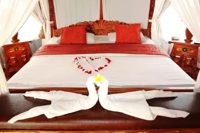 a bed with two towels and a heart and a pair of hearts at Dewani Villa Resort in Canggu