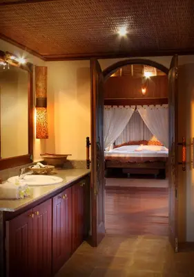 a bathroom with a sink and a bed in the background at Dewani Villa Resort in Canggu