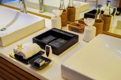 a bathroom counter with a sink and a box of soap at Maca Villas & Spa Bali in Seminyak