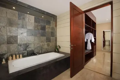 a bathroom with a bath tub and a shower at Amadea Resort & Villas Seminyak Bali in Seminyak