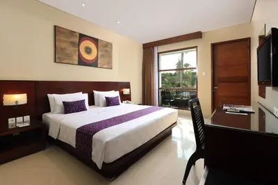 a bedroom with a bed and a desk and a television at Amadea Resort & Villas Seminyak Bali in Seminyak