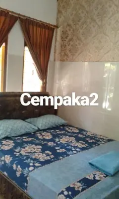 a bed in a room with a sign that says compania at Cempaka 2 Homestay in Legian