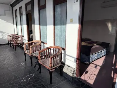 a row of chairs and beds on a building at Cempaka 2 Homestay in Legian