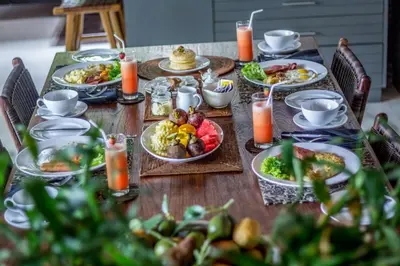 a long table with plates of food on it at Chimera Villas in Seminyak