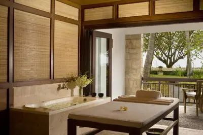 a bathroom with a bath tub and a table and a table sidx sidx at The Patra Bali Resort & Villas - CHSE Certified in Kuta