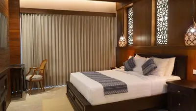 a bedroom with a bed and a desk and a chair at Bali Tropic Resort & Spa - CHSE Certified in Nusa Dua