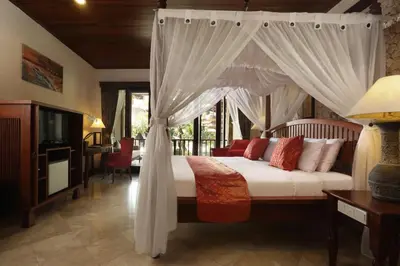 a bedroom with a bed with a canopy at Bali Tropic Resort & Spa - CHSE Certified in Nusa Dua
