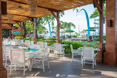 a group of tables and chairs on a patio at Bali Tropic Resort & Spa - CHSE Certified in Nusa Dua
