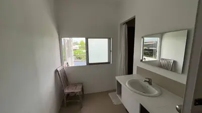 a white bathroom with a sink and a mirror at Kampoeng Saya in Seminyak
