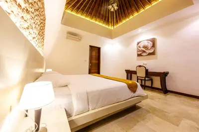 a bedroom with a bed and a desk in a room at Villa Suzuki 1 Seminyak in Seminyak