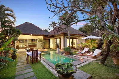 a villa with a swimming pool and a house at The Buah Bali Villas in Seminyak