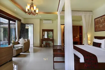 a bedroom with a bed and a living room at The Buah Bali Villas in Seminyak