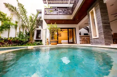 a swimming pool in front of a house at Villa Suzuki 3 Seminyak in Seminyak