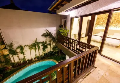 a balcony of a house with a swimming pool at Villa Suzuki 3 Seminyak in Seminyak