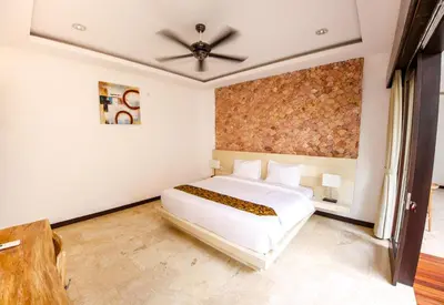 a bedroom with a white bed and a ceiling fan at Villa Suzuki 3 Seminyak in Seminyak