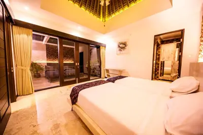 a bedroom with a bed and a large window at Villa Suzuki 3 Seminyak in Seminyak