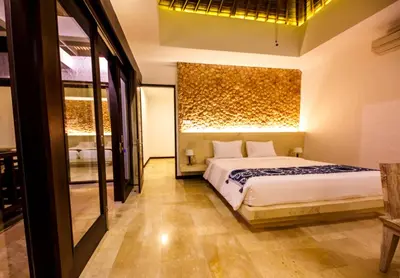 a bedroom with a bed and a mirror at Villa Suzuki 3 Seminyak in Seminyak